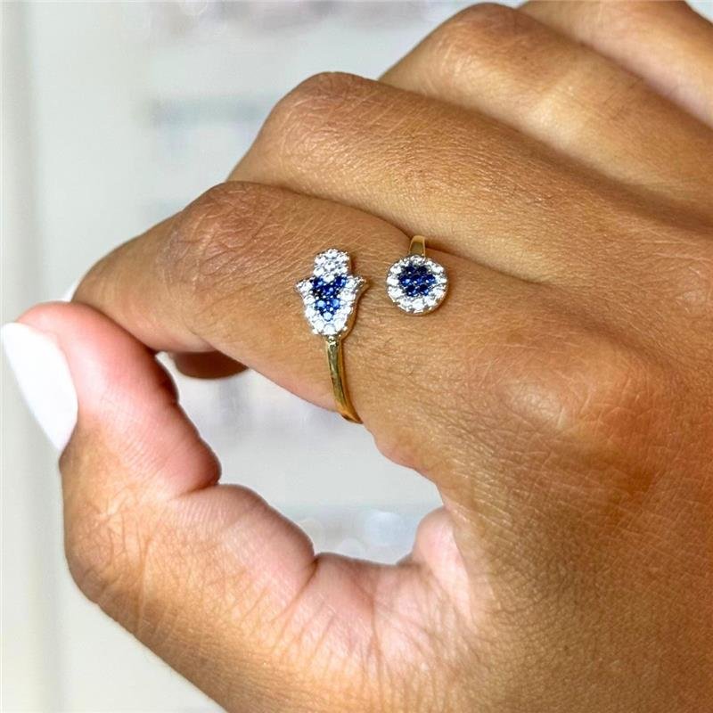 ANEL MÃO DE FÁTIMA E OLHO GREGO CRAVEJADOS COM ZIRCÔNIAS AQUAMARINE E CRISTAL FOLHEADO A OURO
