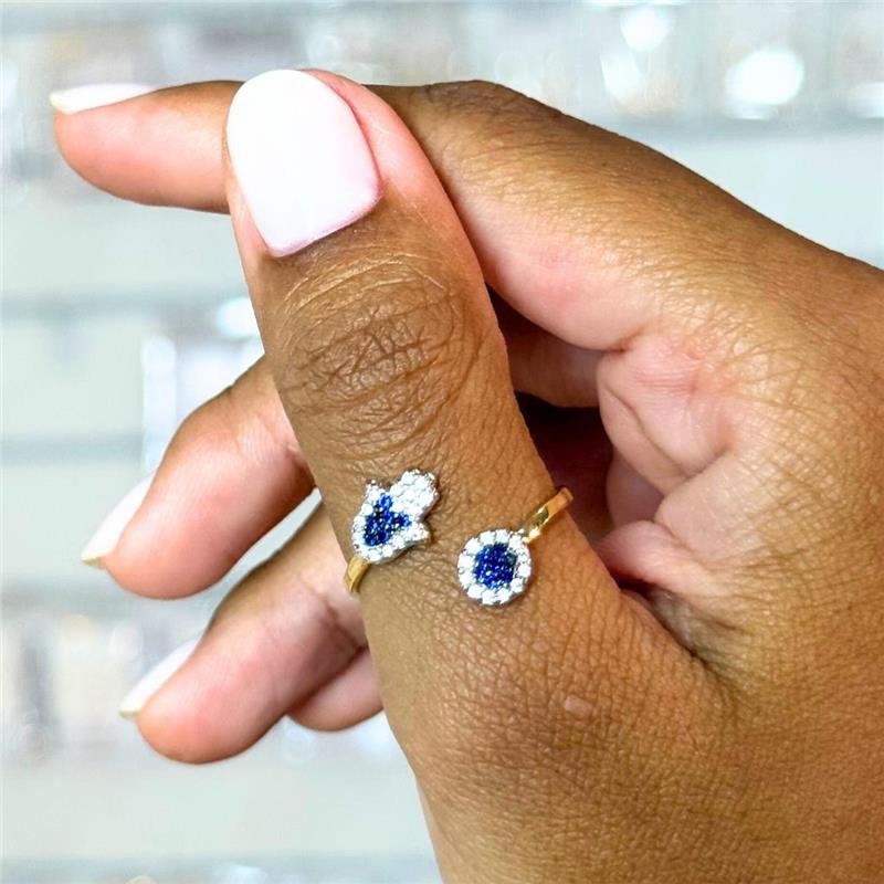 ANEL MÃO DE FÁTIMA E OLHO GREGO CRAVEJADOS COM ZIRCÔNIAS AQUAMARINE E CRISTAL FOLHEADO A OURO